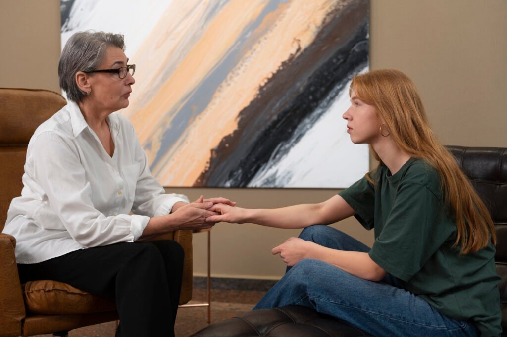 Young woman speaking with a therapist during a counseling session about anxiety, depression, emotional stress, and mental health support